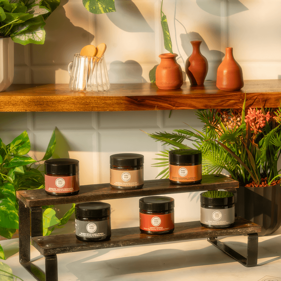 Jars on a wooden shelf with decorative vases and plants in the background