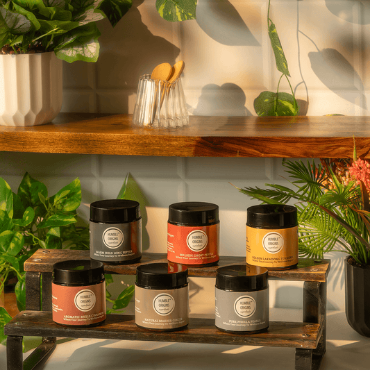 Collection of cosmetic jars on a wooden shelf with plants in the background