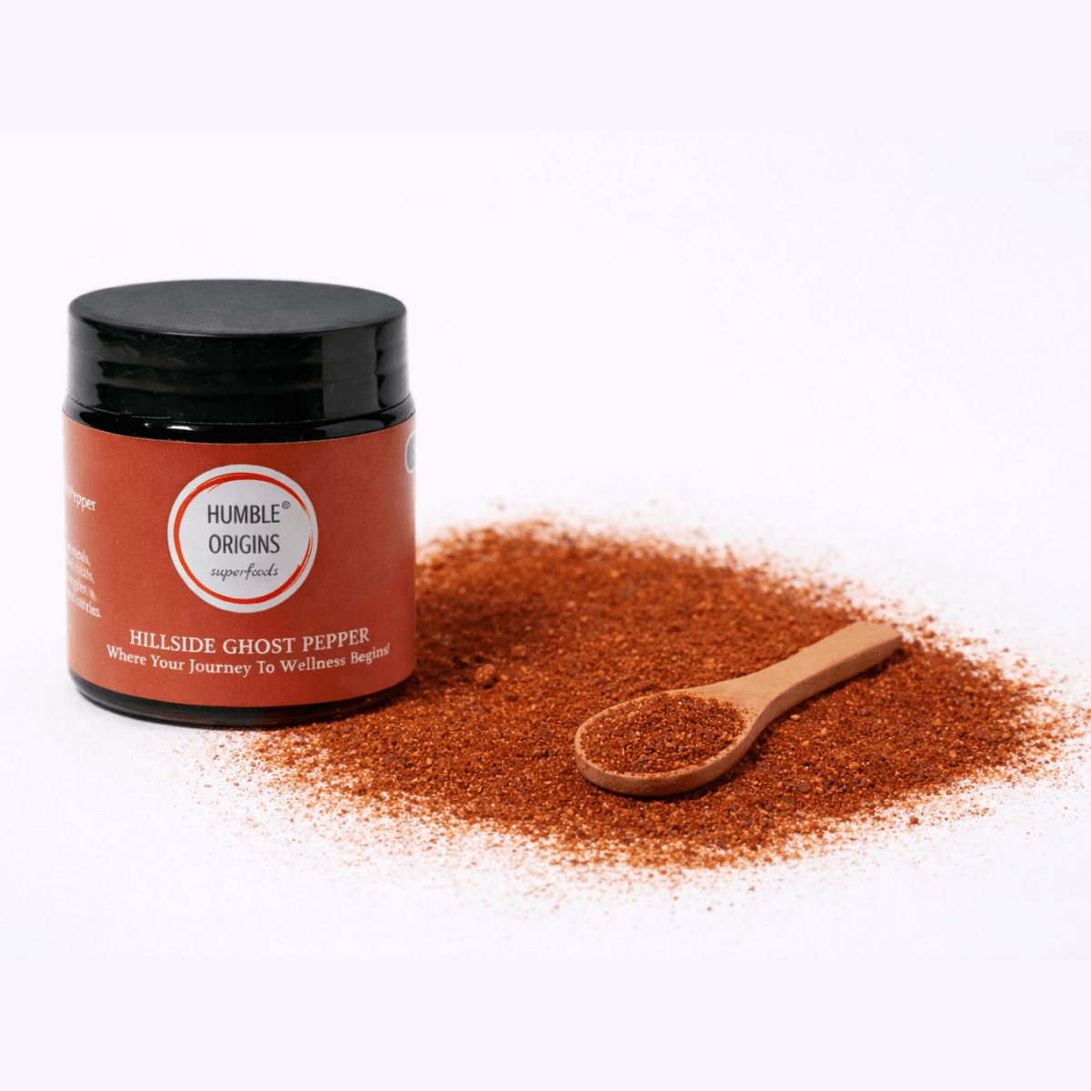 Jar of Hillside Ghost Pepper powder with a wooden spoon on a white background