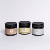 Three jars of different colors with black lids on a light gray background