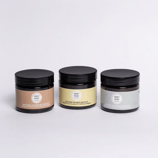 Three jars of different colors with black lids on a light gray background