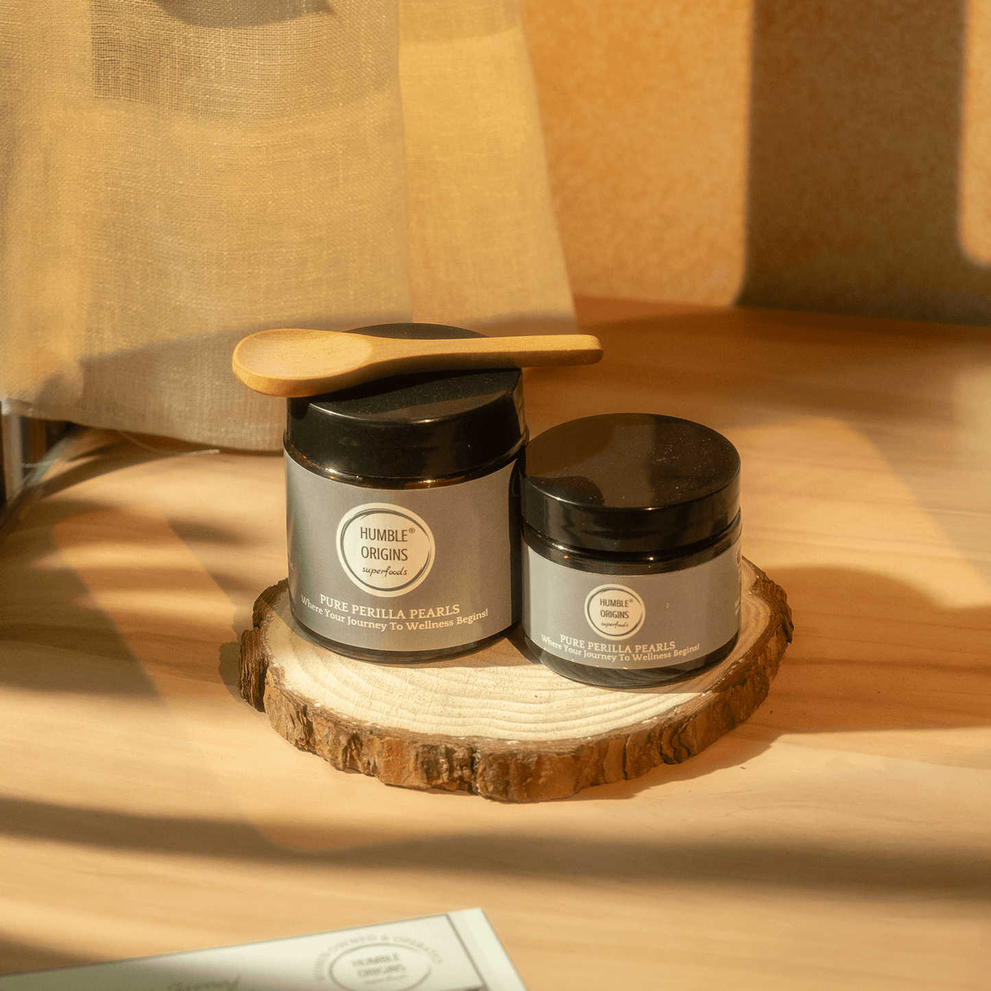 Two jars with labels on a wooden surface with a soft focus background