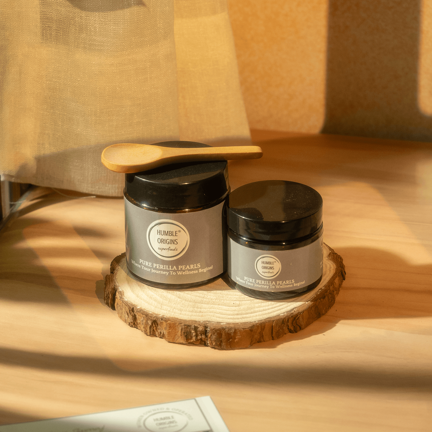 Two jars with labels on a wooden surface with a soft focus background